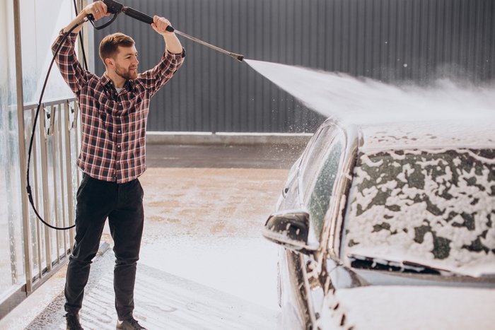 young-man-washing-his-car-carwash.jpg